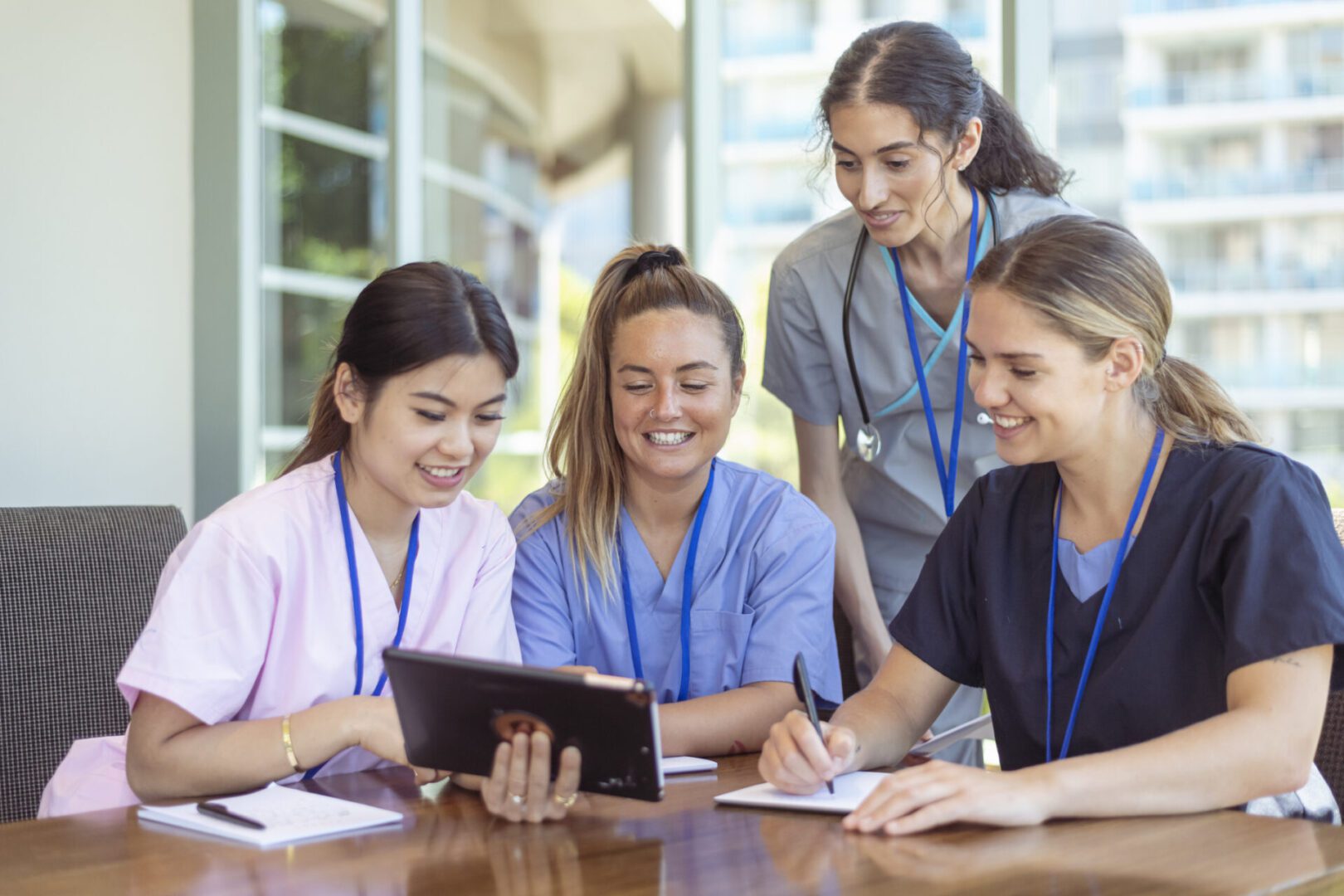 Nurses collaborating while reviewing digital tablet.