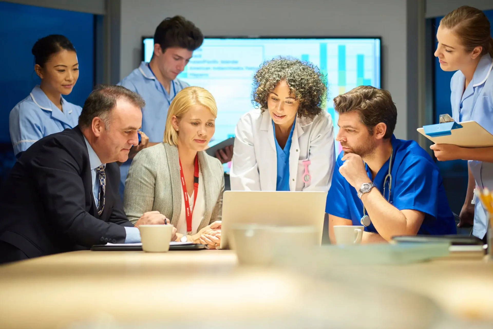 A team of professionals discussing data on a laptop.